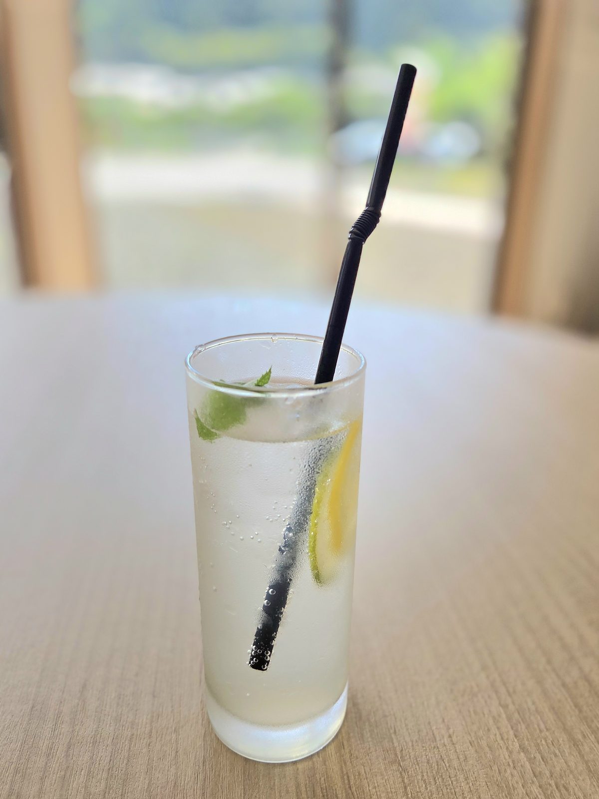ストローを差したレモン入りの冷たいスカッシュ